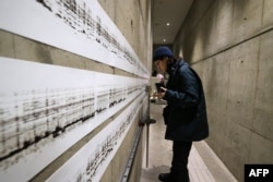 A visitor tries out an installation set up with a series of sound-producing devices and mechanisms at an exhibition entitled 'Iran's Sound Scene' in Tehran, Iran, on Feb. 4, 2025.