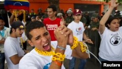 Un grupo de estudiantes se encadenan en señal de protesta cerca a la embajada de Cuba y exigen a la isla que no interfiera en el gobierno venezolano.