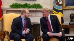 President Donald Trump speaks with Joshua Holt, who had been detained in Venezuela for two years, in the Oval Office at the White House in Washington, on May 26, 2018. 