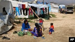 叙利亚妇女在黎巴嫩贝卡谷地巴埃利亚斯镇一个难民营的帐篷外为家人准备饭食（2016年3月29日）