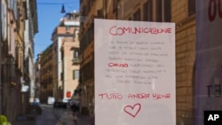 A hand written notice on the window of a shop advises that the shop will remain close for public health reason, concluding "All will be fine", in downtown Rome, March 12, 2020. 