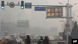 Una señal de tránsito en Beijing dice "Baja visilidad, reduzca la velocidad" en un día de alta contaminación, el lunes, 30 de noviembre de 2015.
