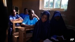 Students of Excellent Moral School attend a lesson in a dimly lit classroom in Ibadan, Nigeria, May 28, 2024. Schools like Excellent Moral operate in darkness due to zero grid access, depriving students of essential tools like computers.
