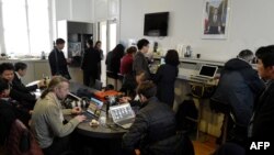 FILE - Journalists work in the press room of the Elysee Palace on March 27, 2018, in Paris. 