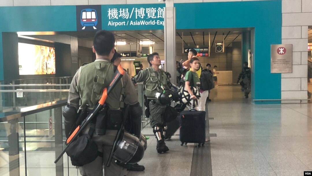 Polisi anti huru-hara berjaga di kereta ekspress bandara di Stasiun Hong Kong, September 2019.