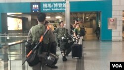 Polisi anti huru-hara berjaga di kereta ekspress bandara di Stasiun Hong Kong, September 2019.