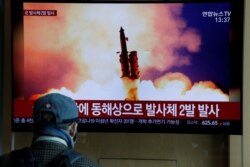 A man watches a TV showing a file picture for a news report on North Korea firing two unidentified projectiles, in Seoul, South Korea, March 2, 2020.