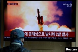 A man watches a TV showing a file picture for a news report on North Korea firing two unidentified projectiles, in Seoul, South Korea, March 2, 2020.
