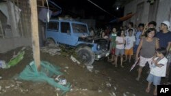 Warga berkumpul di depan rumah yang runtuh di Cagayan De Oro, Filipina, menyusul gempa berkekuatan 7,6 skala Richter. (Foto: AP)