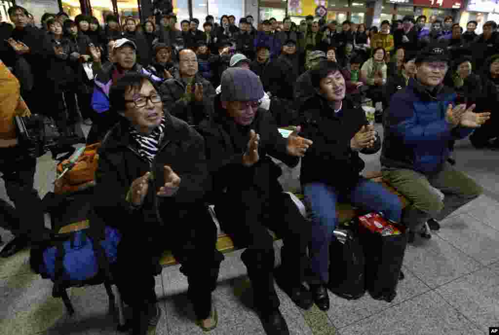 South Koreans cheer as they watch a television broadcast of the country's first rocket launch at Seoul Railway Station in Seoul, South Korea, January 30, 2013.