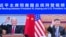 In this photo released by Xinhua News Agency, Chinese President Xi Jinping, right, and U.S. President Joe Biden appear on a screen as they hold a meeting via video link, in Beijing, China, Nov. 16, 2021. 