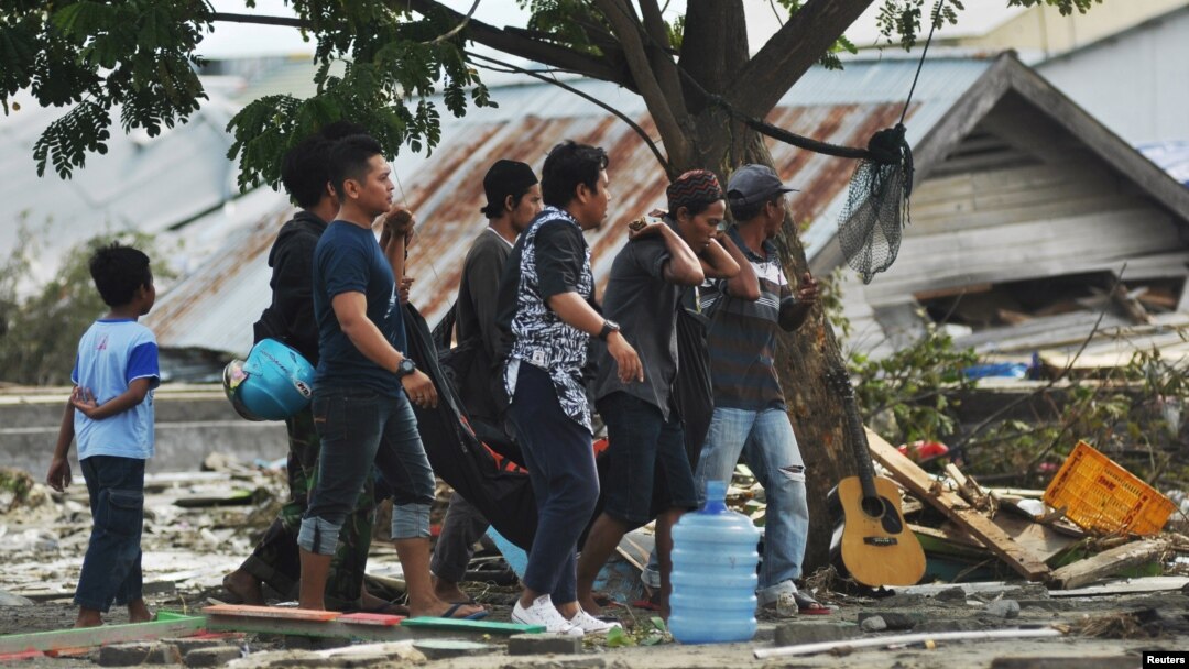 Warga mengevakuasi jenazah korban gempa bumi dan tsunami di Palu, Sulawesi Tengah, 29 September 2018. (Foto: Antara via Reuters)