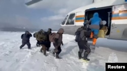 Para nelayan yang terdampar di bongkahan es yang hanyut di Laut Okhotsk di Pasifik Barat, menaiki helikopter saat operasi penyelamatan di wilayah Sakhalin, Rusia, 12 Februari 2025, dalam tangkapan layar video. (Foto: Kementerian Darurat Rusi via Reuters)