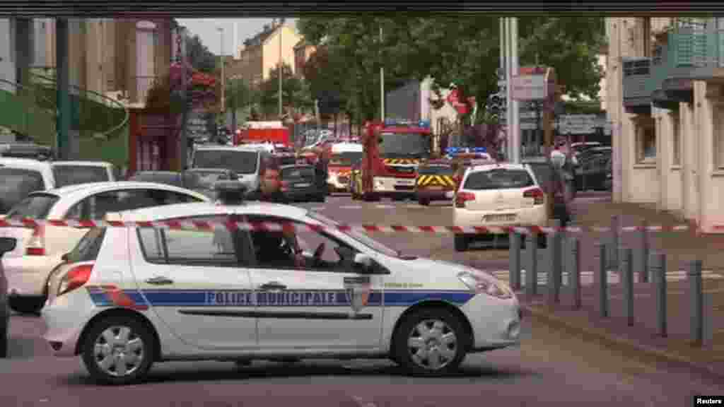 In this grab made from video, police officers close off a road during a hostage situation in Normandy, France on July 26, 2016.