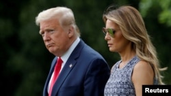 FILE - U.S. President Donald Trump and first lady Melania Trump walk to the Marine One helicopter from the South Lawn of the White House in Washington, May 27, 2020. 