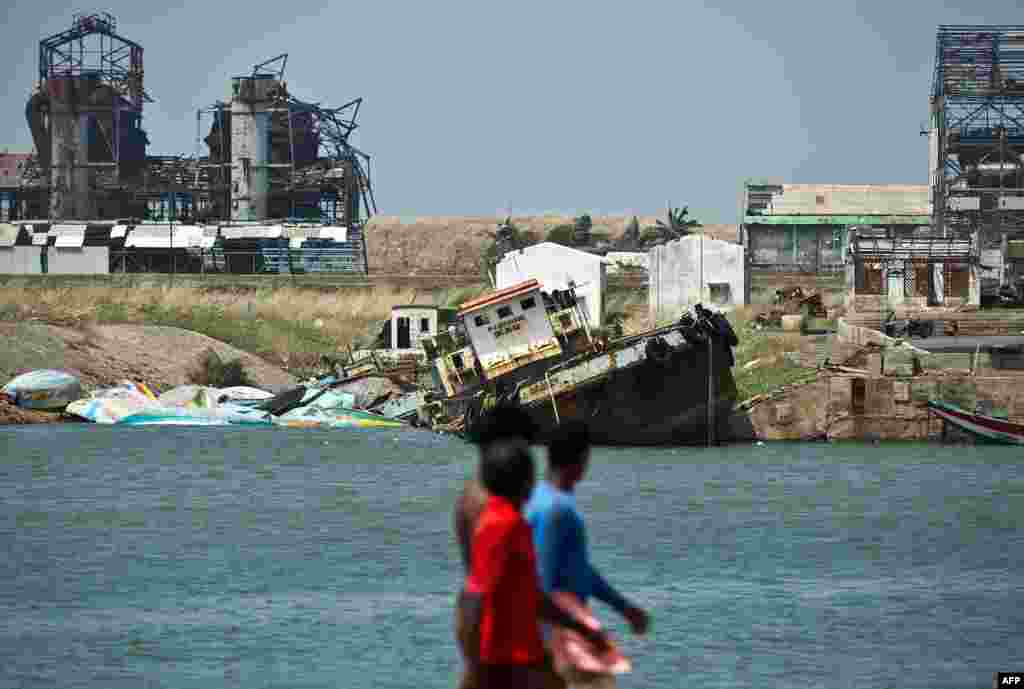 Nelayan India melihat perahu yang hancur akibat topan Phailin di Pelabuhan Gopalpur.