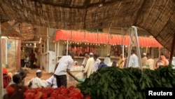 FILE - Men wait to buy food at Khartoum's central food market.