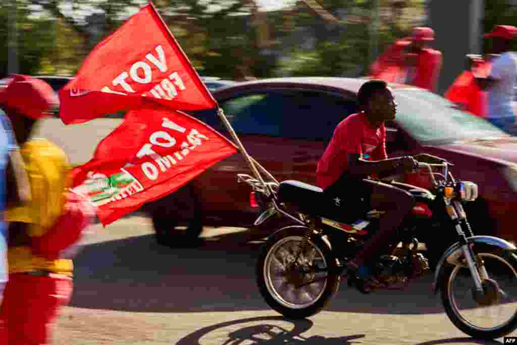 Motociclista transportando bandeiras da Frelimo