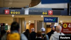 Travelers head towards a security checkpoint at Seattle-Tacoma International Airport in SeaTac, Washington, U.S. April 12, 2021. REUTERS/Lindsey Wasson