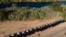 FILE - A line of Texas Department of Safety vehicles lines the bank of the Rio Grande near an encampment of migrants, many from Haiti, Sept. 22, 2021, in Del Rio, Texas. 