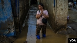 A Thai woman standing in the flooded area of Mae Sai, Thailand, hoping for more help from aid groups Sept. 22, 2024. (Tommy Walker/VOA)