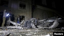 Police officers inspect the site of a car bomb attack in Yemen's capital Sanaa, June 29, 2015.