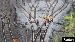 Workers inspect railway tracks for the Belt and Road freight rail route linking Chongqing, China, with Duisburg, Germany, at the Dazhou railway station in Sichuan province, China March 14, 2019.