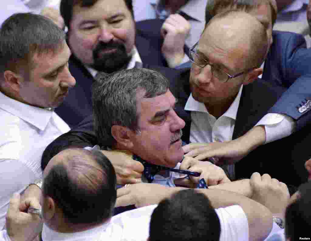 Opposition leader Arseny Yatsenyuk (top R) holds the tie of a deputy from the pro-presidential Party of the Regions (C), as opposition deputies attempt to disrupt a parliament session in Kyiv, Ukraine.