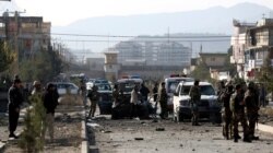 FILE - Afghan security personnel gather at the site of car bomb attack in Kabul, Afghanistan, Nov. 13, 2019. A car bomb detonated in the Afghan capital of Kabul during the morning commute, killing several people, officials said.