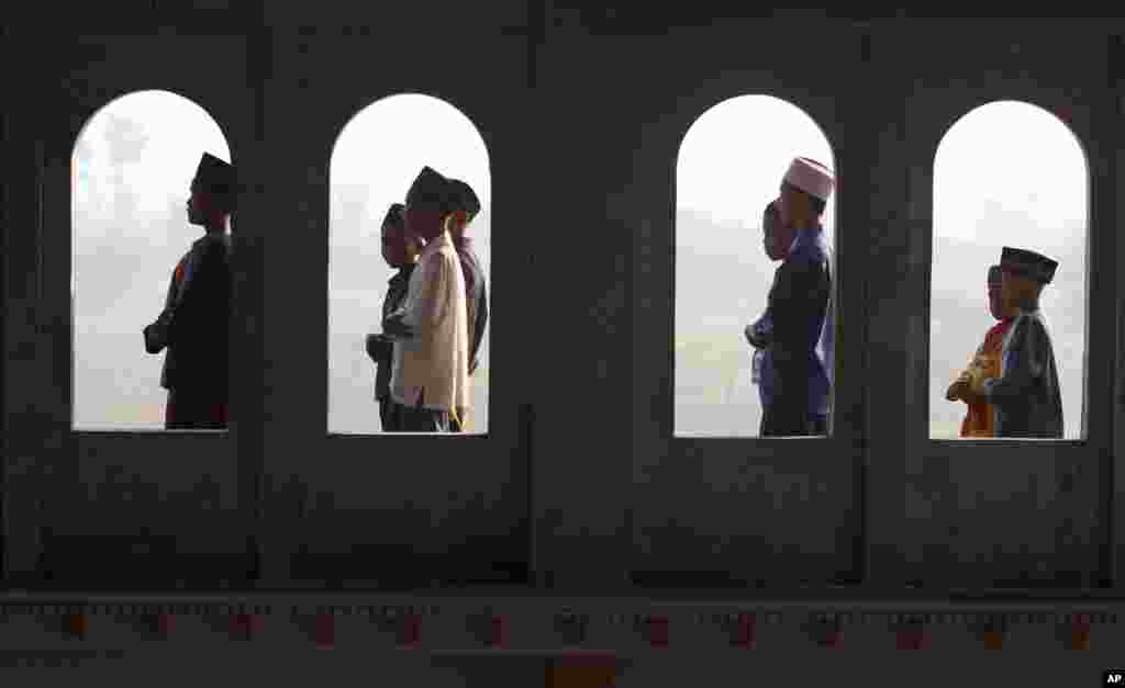 Jemaah sholat Idul Fitri terlihat dari jendela masjid di Porong, Jawa Timur, 8 Agustus 2013.