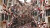 Orang-orang menonton dari balkon dalam festival San Fermin atau lari bersama-sama dikejar banteng di kota Pamplona, Spanyol.