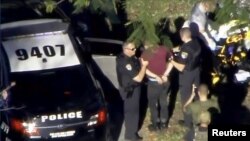 Le suspect Nikolas Cruz arrêté par la police près du lycée Marjory Stoneman Douglas High School à Parkland, en Floride, après la fusillade du 14 février 2018.