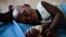 FILE - A young girl with malaria rests in the inpatient ward of the Malualkon Primary Health Care Center in Malualkon, in the South Sudanese state of Northern Bahr el Ghazal, June 1, 2012.