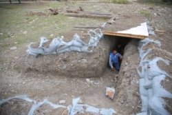 Local residents take shelter in a dugout during the fighting over the breakaway region of Nagorno-Karabakh in the city of Terter, Azerbaijan, Sept. 30, 2020.