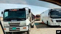 Mobile medical screening unit and cargo trucks park at the closed Pakistan-Iran border crossing, Feb. 25, 2020, in Taftan, Pakistan. 