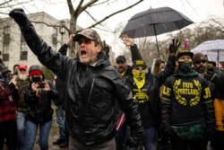 Supporters of President Donald Trump confront riot police as they gathered at the Capitol on Jan. 6, 2021 in Salem, Ore.