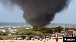 Asap hitam menyelimuti angkasa di atas bandara Internasional Aden Abdule di ibukota Somalia, Mogadishu, akibat meledak dan terbakarnya sebuah pesawat pengangkut senjata milik Ethiopia, Jumat (9/8). 