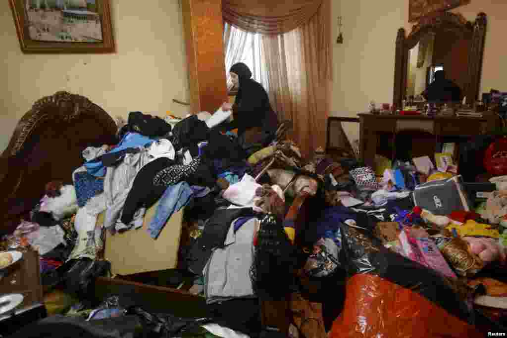 A Palestinian woman inspects the damage to her house, which her family said was searched during an Israeli army raid, following the arrest of a family member by the army in the Askar refugees camp near the West Bank city of Nablus.