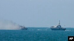 Egipatski ratni brod gasi požar na drugom brodu mornarice u Mediteranu, 16. jula 2015. Egipatski brod zapalio se nadomak obale Sinaja posle razmene vatre sa ekstremistima koji su pucali sa obale. 