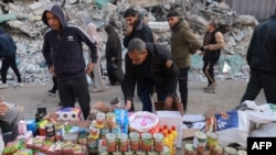 Palestinos caminan frente a mesas con productos improvisadas en una calle de Rafah, en el sur de la Franja de Gaza, en medio de los preparativos para el mes sagrado del Ramadán, el 10 de marzo de 2024.