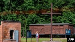 FILE - In this photo taken July 21, 2020, a woman is seen next to a gas chamber at the museum of the former Nazi Death Camp Stutthof, in Sztutowo, Poland.