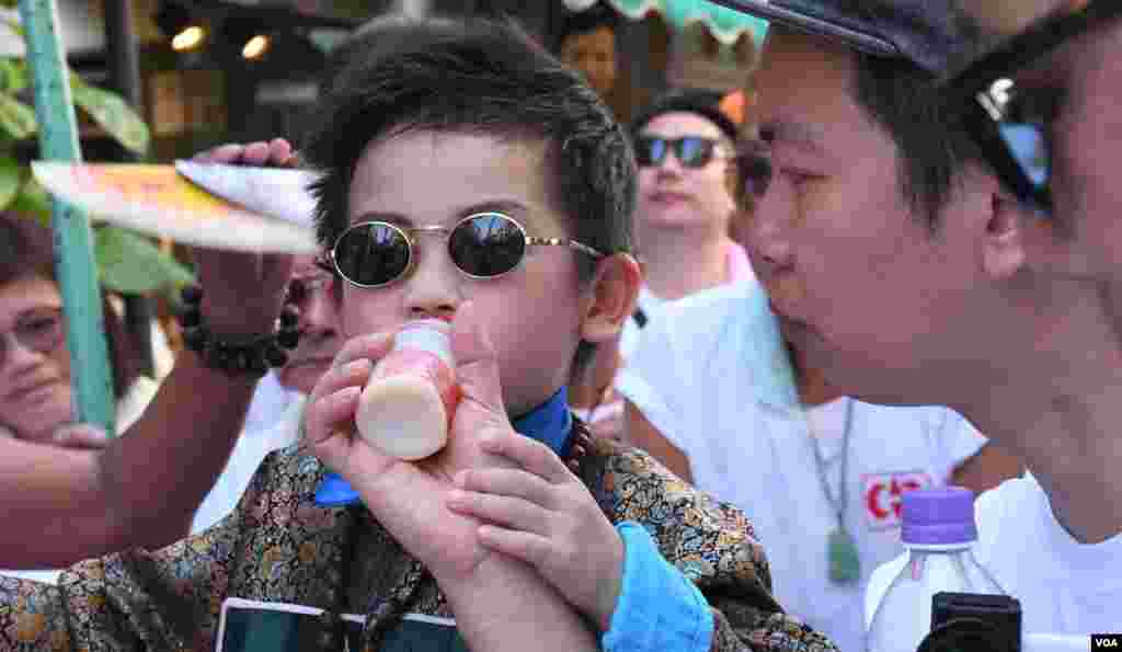 扮演古裝人物的小男孩要喝飲品清熱。(美國之音湯惠芸拍攝)