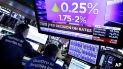 A television screen on the floor of the New York Stock Exchange shows the rate decision of the Federal Reserve, June 13, 2018. 