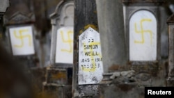 Graves that were desecrated with swastikas are seen at the Jewish cemetery in Quatzenheim, near Strasbourg, France, Feb. 19, 2019.