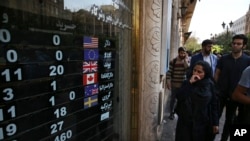 FILE - An exchange shop displays rates for various currencies, in downtown Tehran, Iran, Oct. 2, 2018. A battle is brewing between the Trump administration and some of the president’s biggest supporters in Congress who are concerned that sanctions to be re-imposed on Iran early next month won’t be tough enough.