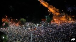 People flash the lights of their mobile phones during an anti-government protest in Victoria Square, outside the government headquarters in Bucharest, Romania, Aug. 10, 2019. 