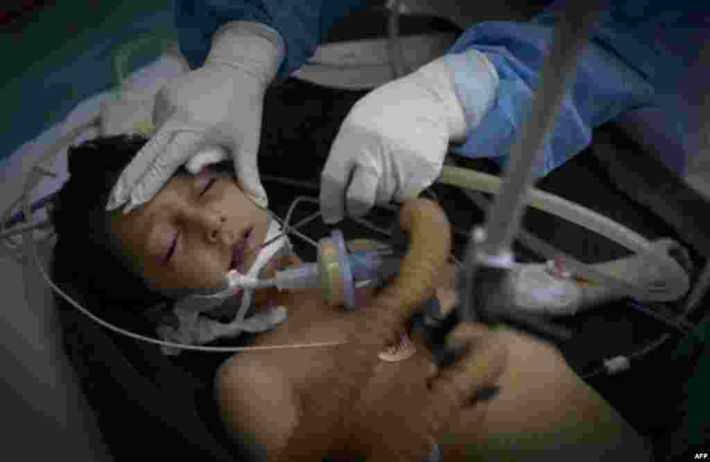 Five-year-old Libyan boy Mohammed Achmed is treated by a doctor in the Jalaa hospital in Benghazi, eastern Libya, Saturday, March 19, 2011. Mohammed received bullet wounds to his chest early Saturday as fighting broke out in Benghazi. He was with his moth