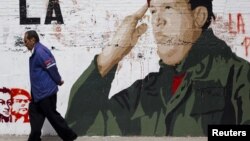 Un hombre pasa en Caracas junto a un mural con la figura de Chávez, cuya salud ha sufrido nuevas complicaciones en La Habana.