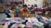 FILE - Workers pack bags with goods imported from China at a company in Bangkok, Thailand, Aug. 7, 2018.