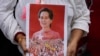 Seorang pengunjuk rasa membawa foto mantan pemimpin Aung San Suu Kyi saat protes peringatan dua tahun pengambilalihan militer di luar Kedutaan Besar Myanmar di Bangkok, Thailand, pada 1 Februari 2023. (Foto: AP)